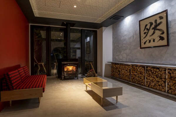 Un salon moderne avec un canapé, une table basse, une cheminée et une grande œuvre d’art encadrée accrochée au mur.
