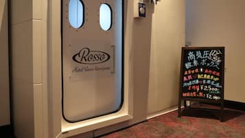 A hotel room door with a window, a sign with Japanese text, and a small signboard with more Japanese text.