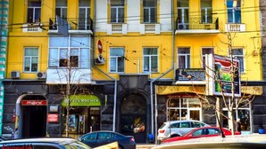A multi-story yellow building with balconies and a central decorative element. - Kyiv City Center (Kyiv)