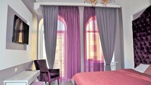 A bedroom with a bed, a desk, a chair, and a TV. - Kyiv City Center (Kyiv)