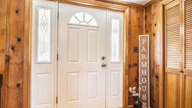 Une porte blanche avec un panneau de verre et une enseigne indiquant « FERME » sur le côté droit.