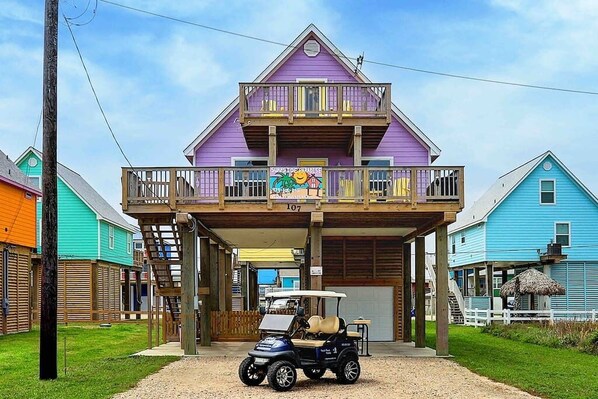 A two-story building with a balcony, a sign reading "Subway Paradise," and a golf cart parked in front.