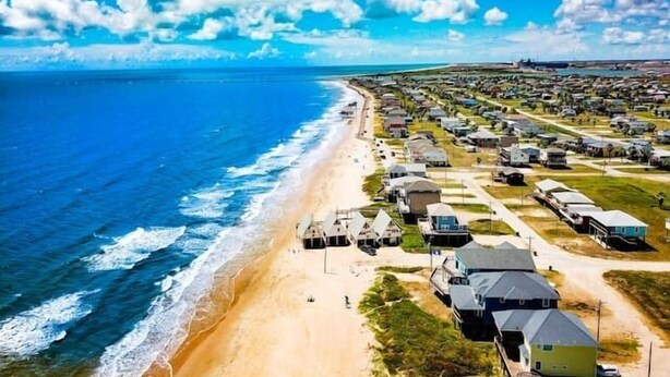 An aerial view of a coastal area with a beach and rows of mobile homes. - 🌴Surfside Paradise#3-amazing views,golfcart🌴 (Surfside Beach)