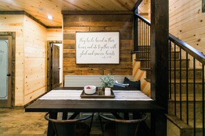 A wooden interior with a table, chairs, a bench, and a staircase. - Free at Last- Romantic, Hot Tub, Loft, Free Firewood, Great Location! (Broken Bow)