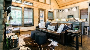 A spacious living room with a leather sofa, a cowhide rug, and a wooden ceiling. - Free at Last- Romantic, Hot Tub, Loft, Free Firewood, Great Location! (Broken Bow)
