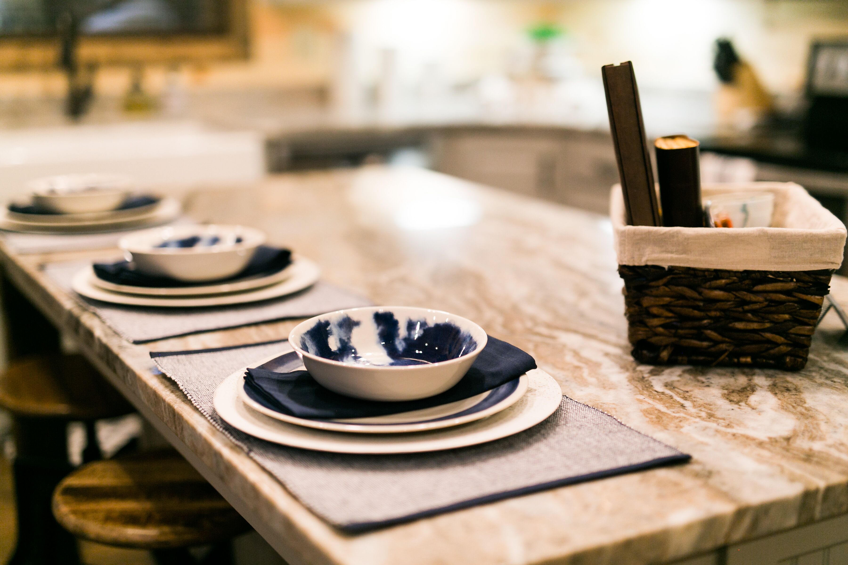 Una mesa puesta con cuencos y platos, una cesta tejida con palillos y una servilleta.