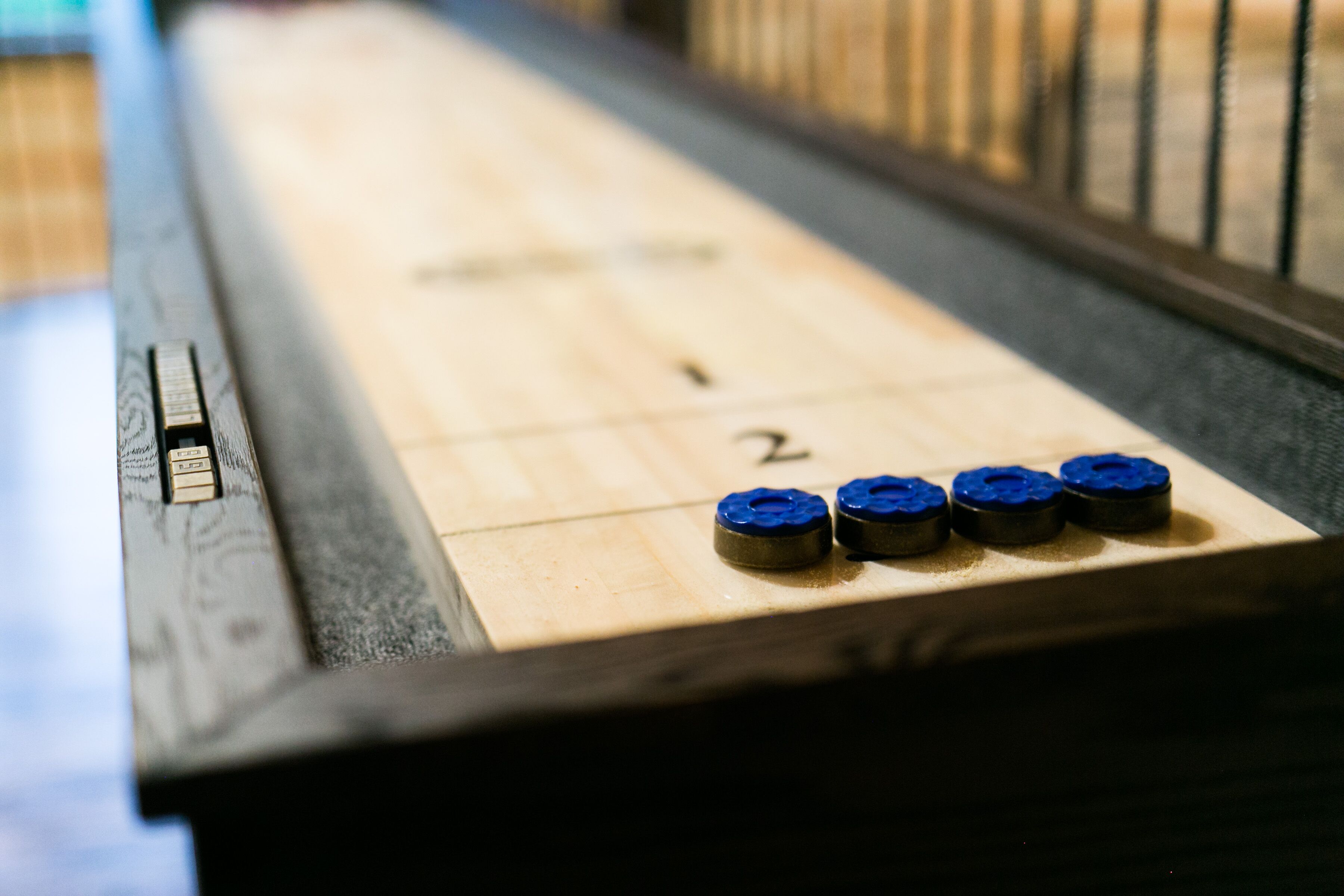 Ein Nahblick auf ein Shuffleboard-Spielfeld mit nummerierten Zählfeldern.