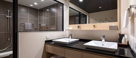 Een moderne badkamer met twee wastafels, een grote spiegel en een douche.