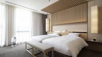 Een moderne hotelkamer met een groot bed, een bankje en een nachtkastje.