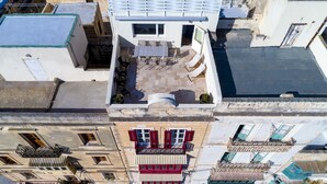 A rooftop terrace with a dining area, a small pool, and a view of the surrounding buildings. - The Snop House (Senglea)
