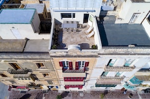 Una terraza en la azotea con zona de comedor, una piscina pequeña y vistas de los edificios circundantes.