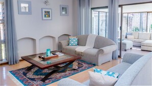 A living room with a sofa, a coffee table, and a patterned rug.