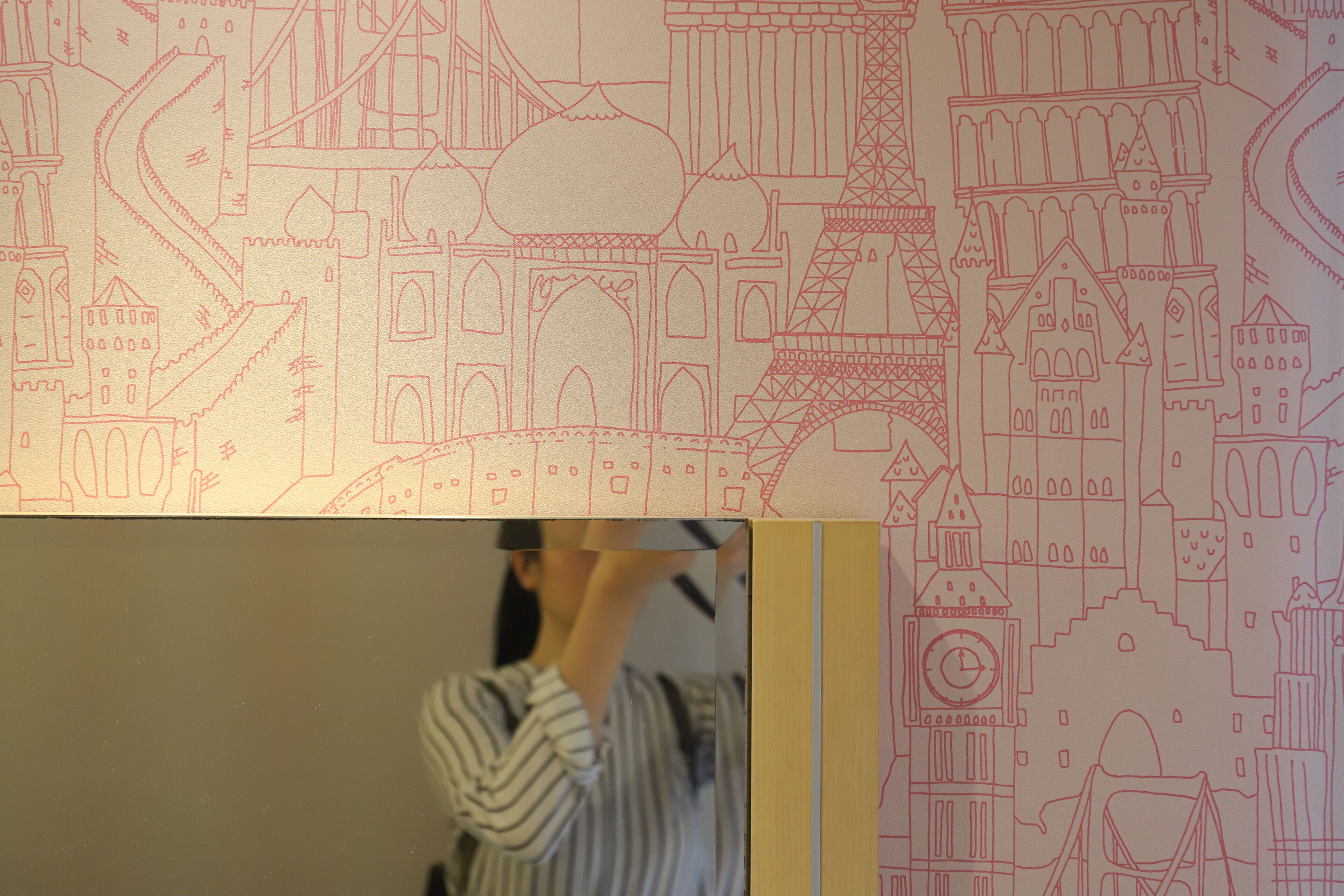 A person standing in front of a wall with a detailed architectural drawing.