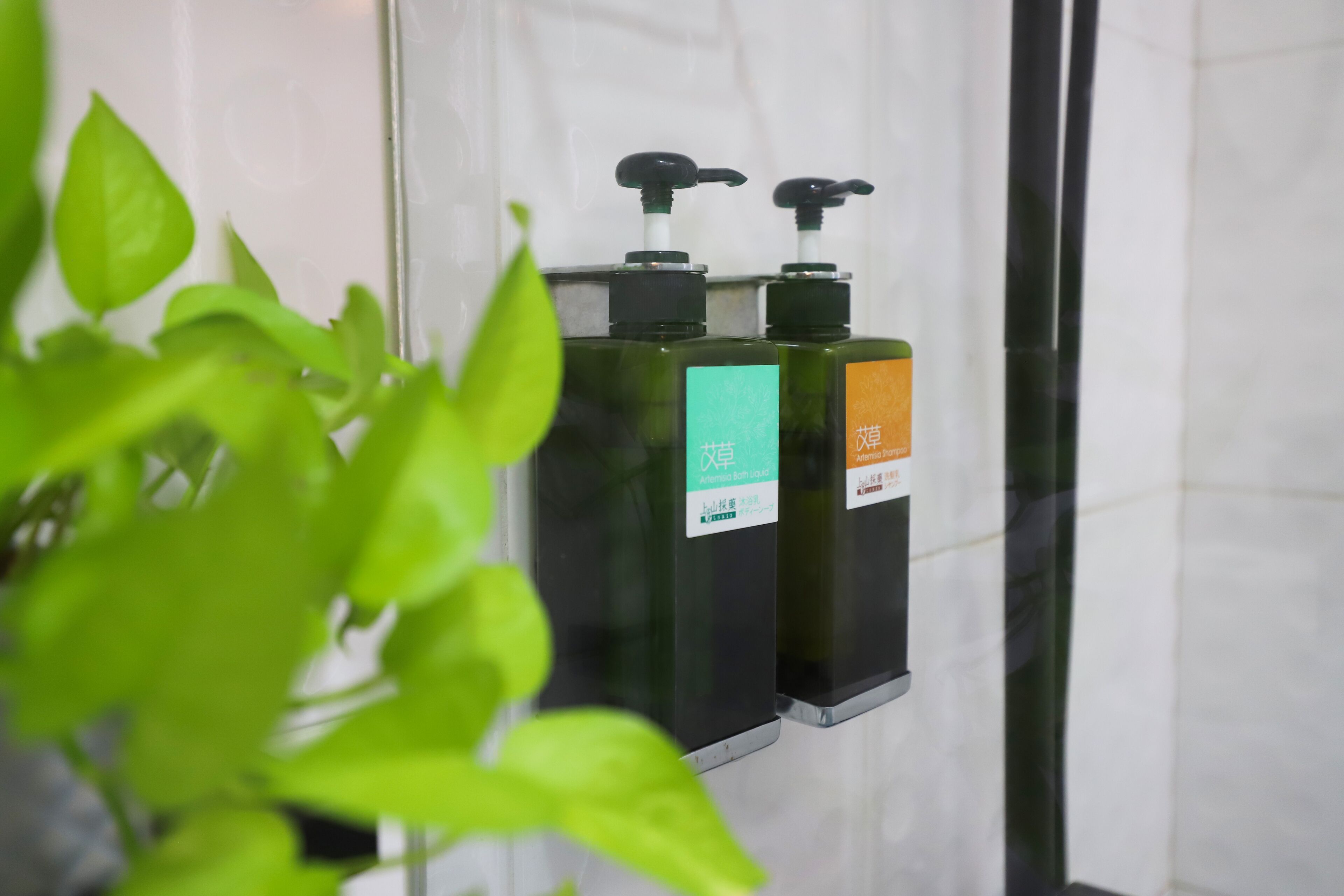 A bathroom with two hand sanitizer dispensers mounted on a wall.