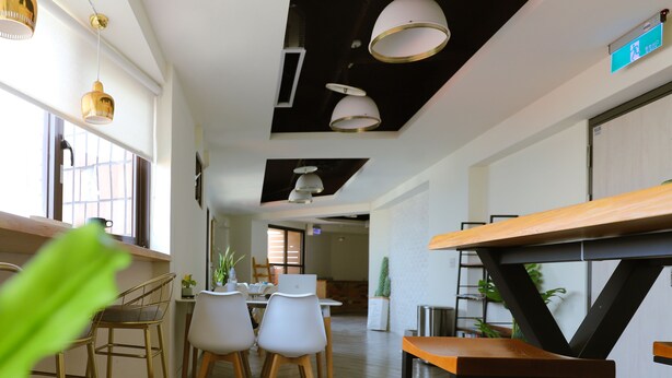 A modern interior with a kitchen area, dining space, and a hallway leading to another room.