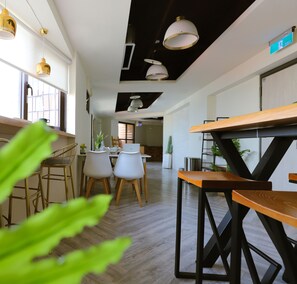 A modern interior with a kitchen area, dining space, and a hallway leading to another room. - Dream 12 Hotel (Taichung)