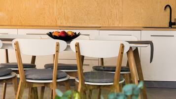 A modern kitchen with wooden cabinets, a white countertop, and a black faucet.