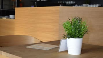 A wooden table with a potted plant and a menu.