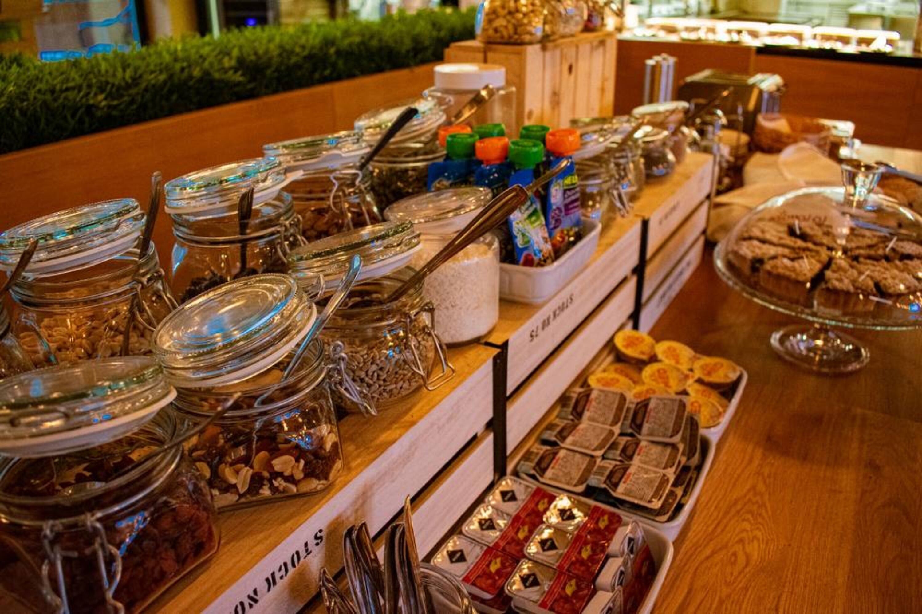 Un buffet con diverse pietanze, tra cui barattoli di frutta secca, cioccolato e dolci.