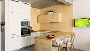 Una cucina moderna con mobili bianchi, un'isola in legno e un forno a microonde integrato.