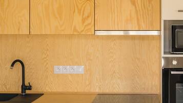 A modern kitchen with wooden cabinets, a stainless steel sink, and a built-in oven.