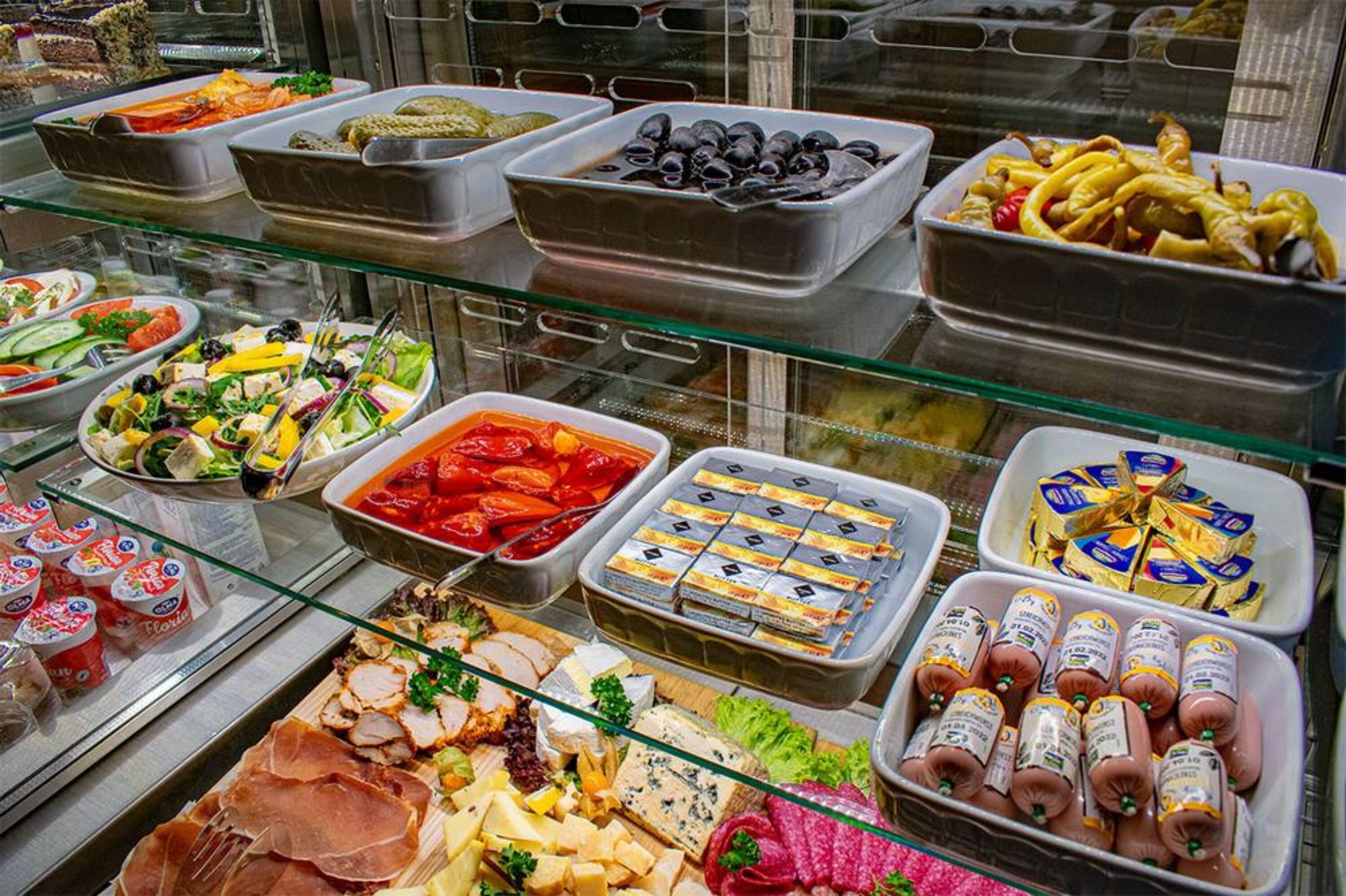 A buffet with various food items including meats, cheeses, and salads.