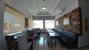 Un restaurant doté d’un long comptoir, de sièges confortables et de tableaux encadrés aux murs.