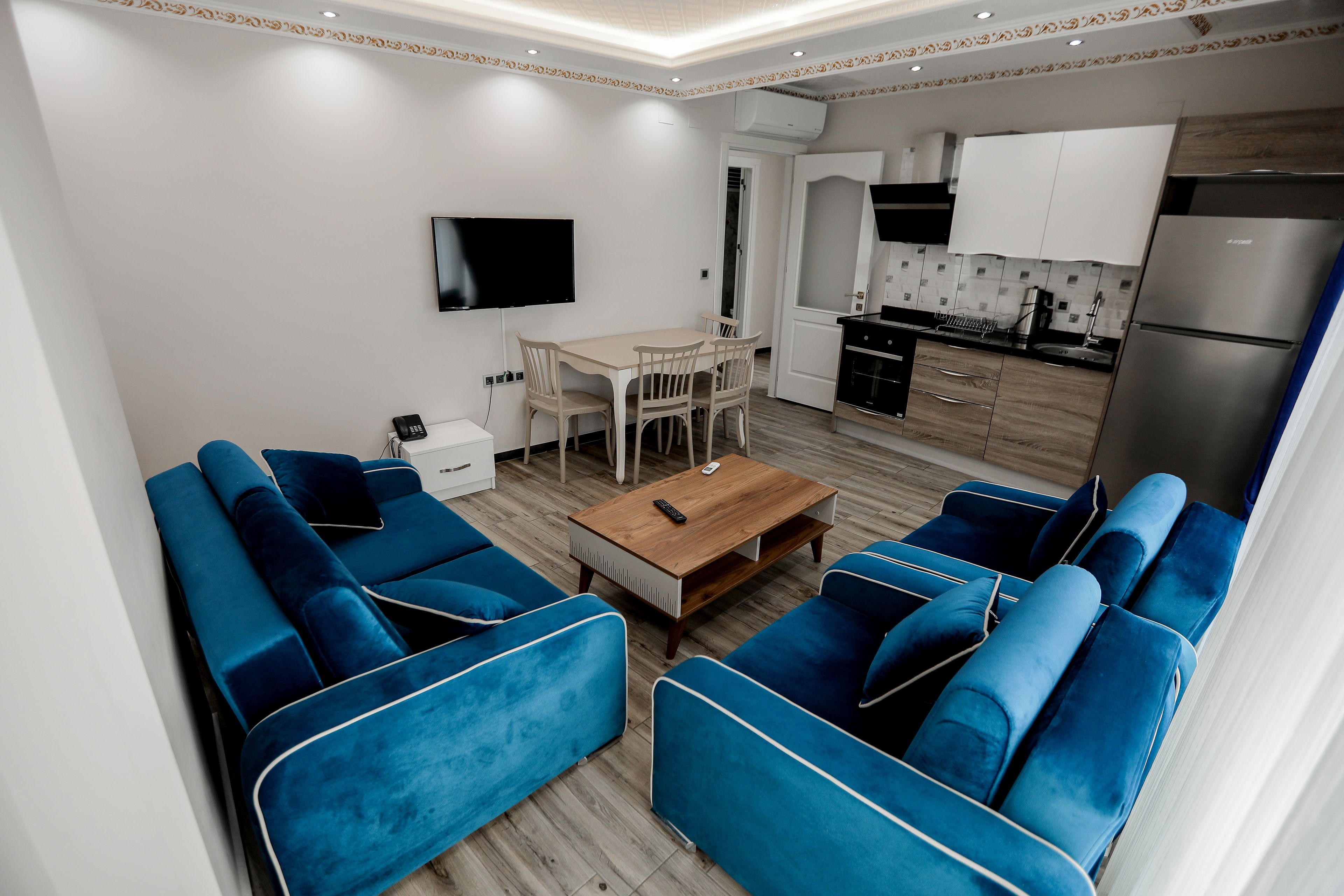Una sala de estar moderna con sofás azules y una mesa de centro de madera.