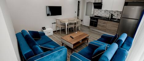 Una sala de estar moderna con sofás azules y una mesa de centro de madera.