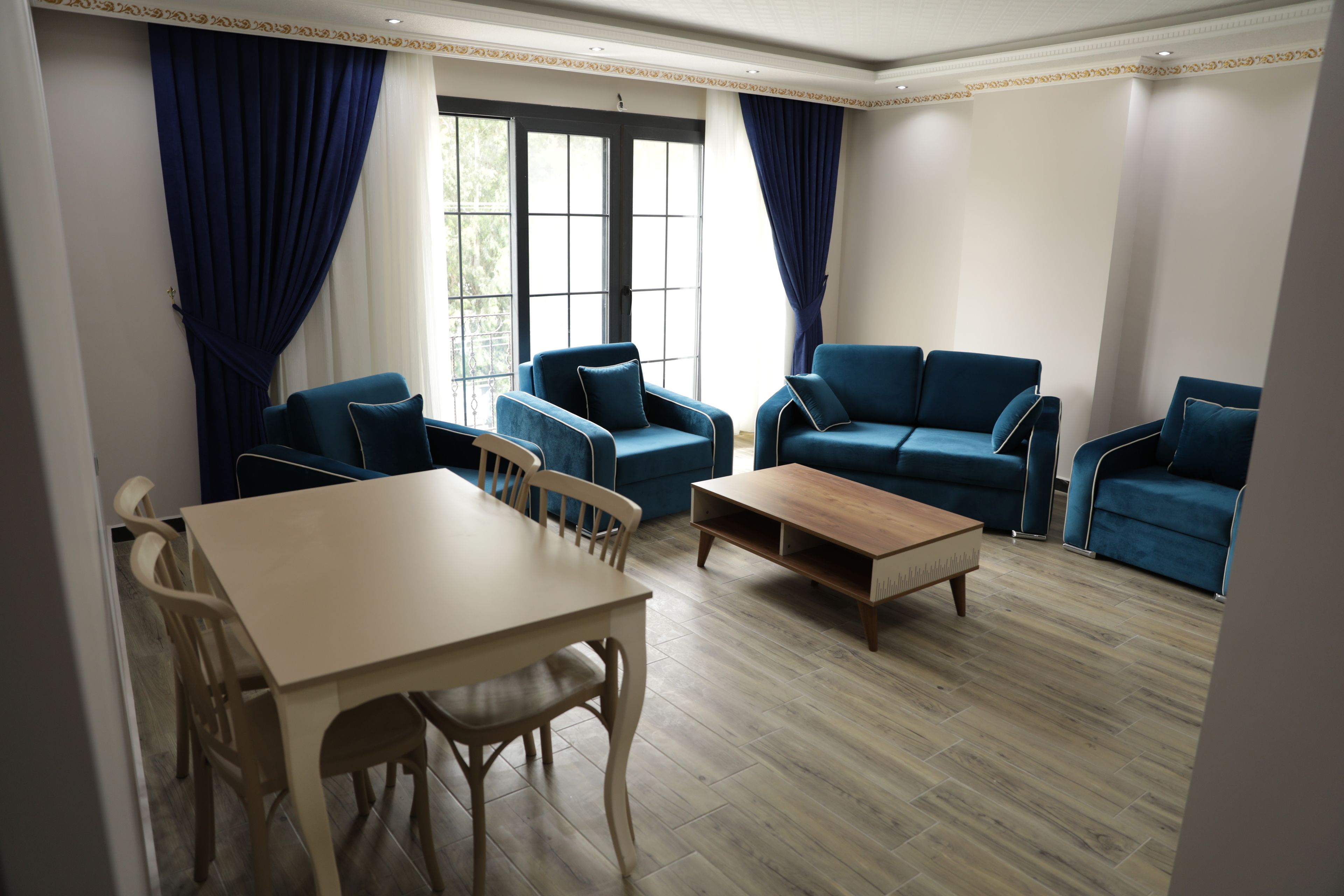 Ein Wohnzimmer mit einem Holztisch, blauen Sofas und einem Couchtisch.