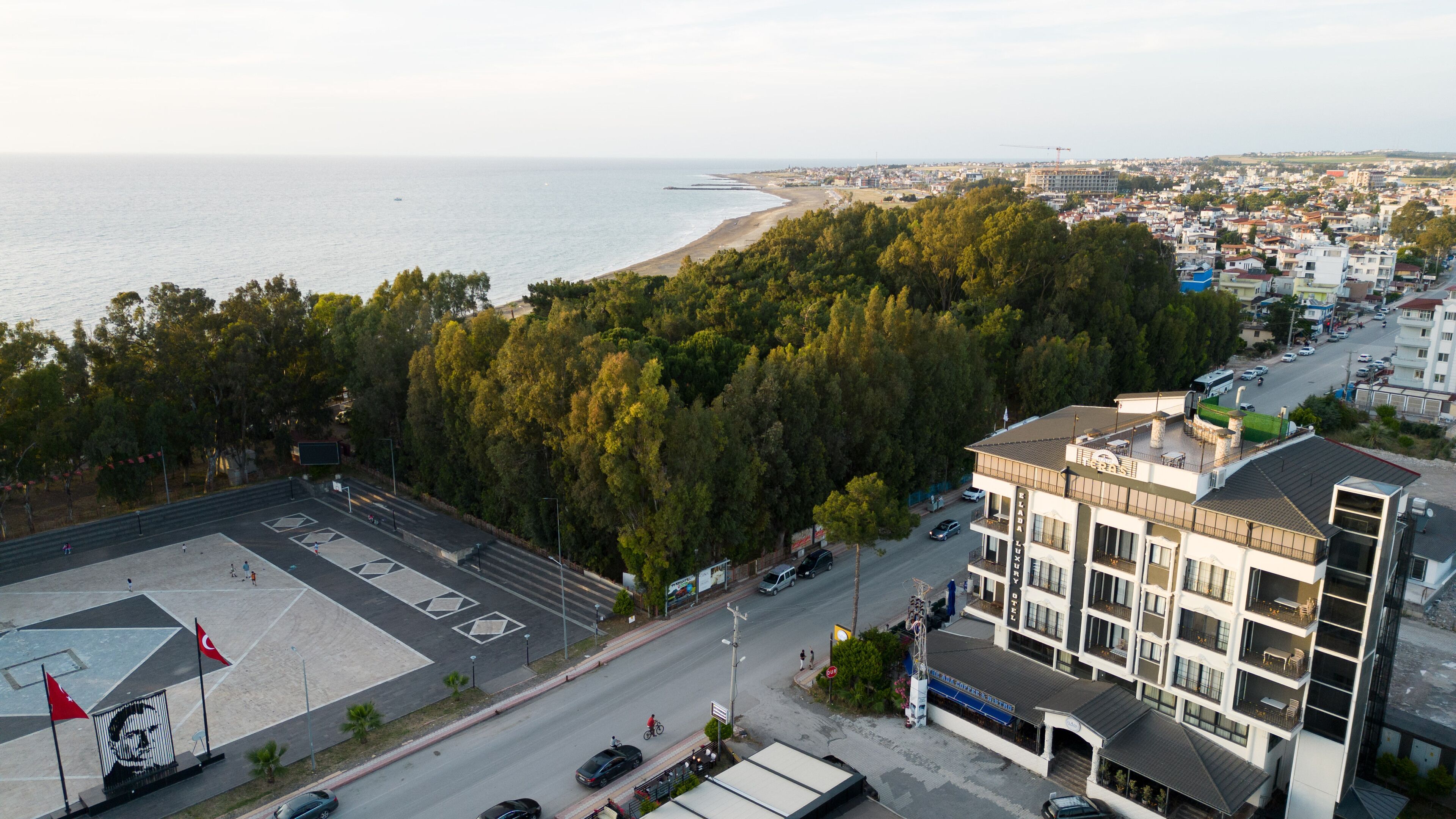 Un edificio de varios pisos con balcones, estacionamiento y vista al mar.