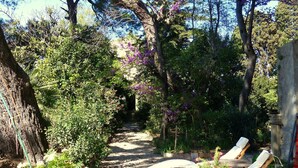 A garden pathway leading to a seating area with sun loungers. - Château de Puichéric (Puicheric)