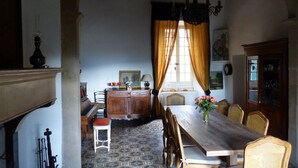 A dining room with a wooden table, chairs, and a chandelier. - Château de Puichéric (Puicheric)