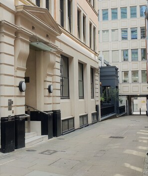 A building with a classical facade, large windows, and a gated entrance.