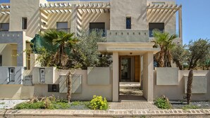 Un bâtiment moderne à la façade symétrique, doté de grandes fenêtres et d’une entrée centrale.