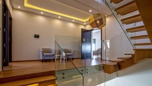 Un intérieur moderne avec un escalier en verre, un plancher en bois et des meubles contemporains.
