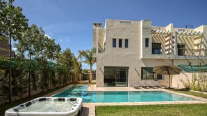 Un bâtiment moderne à deux étages, doté d’une piscine et d’un jacuzzi.