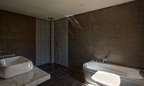 Une salle de bain moderne avec une baignoire sur pieds, un espace douche séparé et un comptoir en marbre.