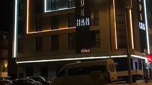 A modern building with illuminated signage reading "DEDE HAN" and "Hotel". - Dedehan Otel (Arsin)