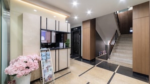 A reception area with a counter, a staircase, and a bulletin board.