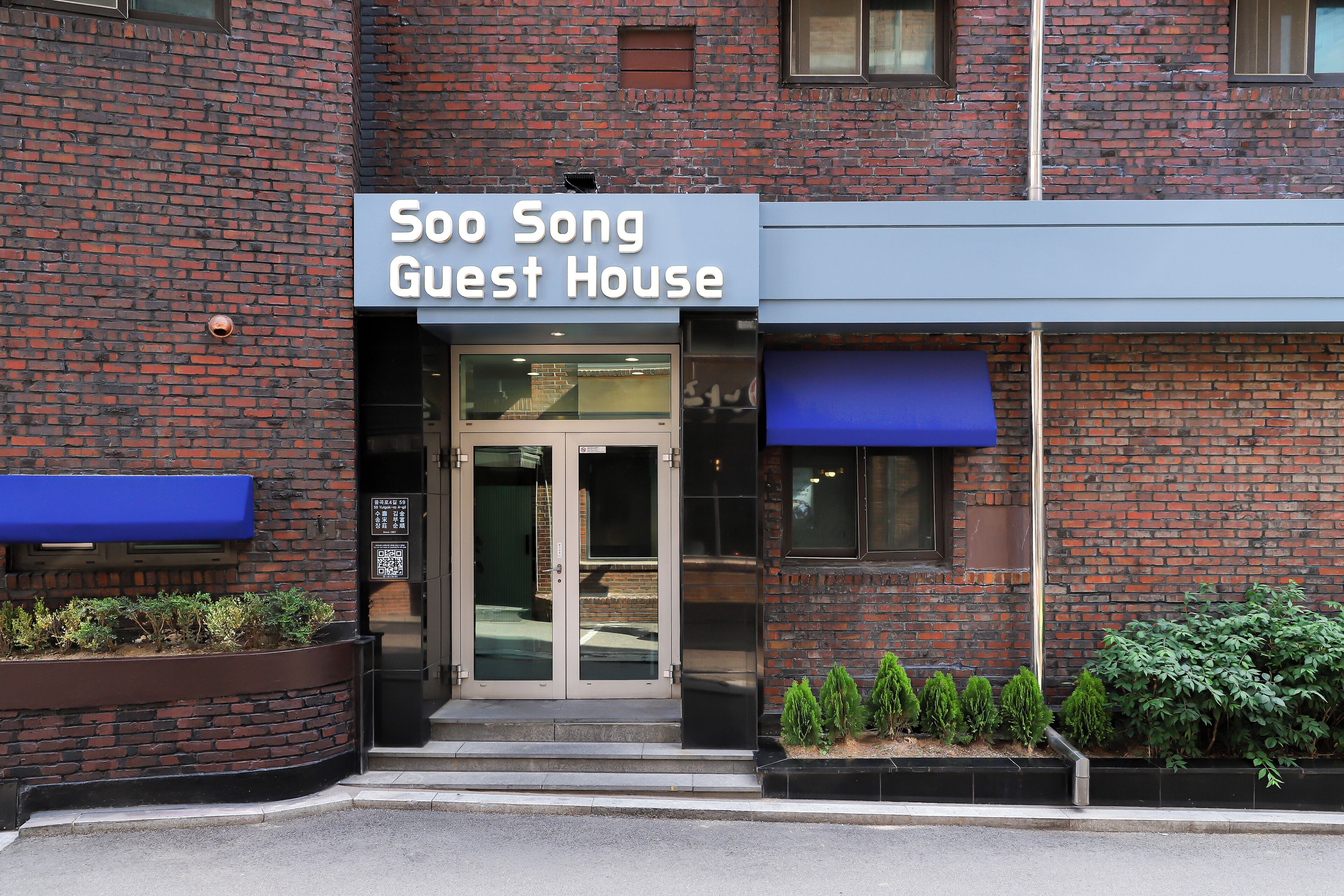 A brick building with a sign reading 'Soo Song Guest House.'