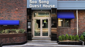 A brick building with a sign reading 'Soo Song Guest House.'