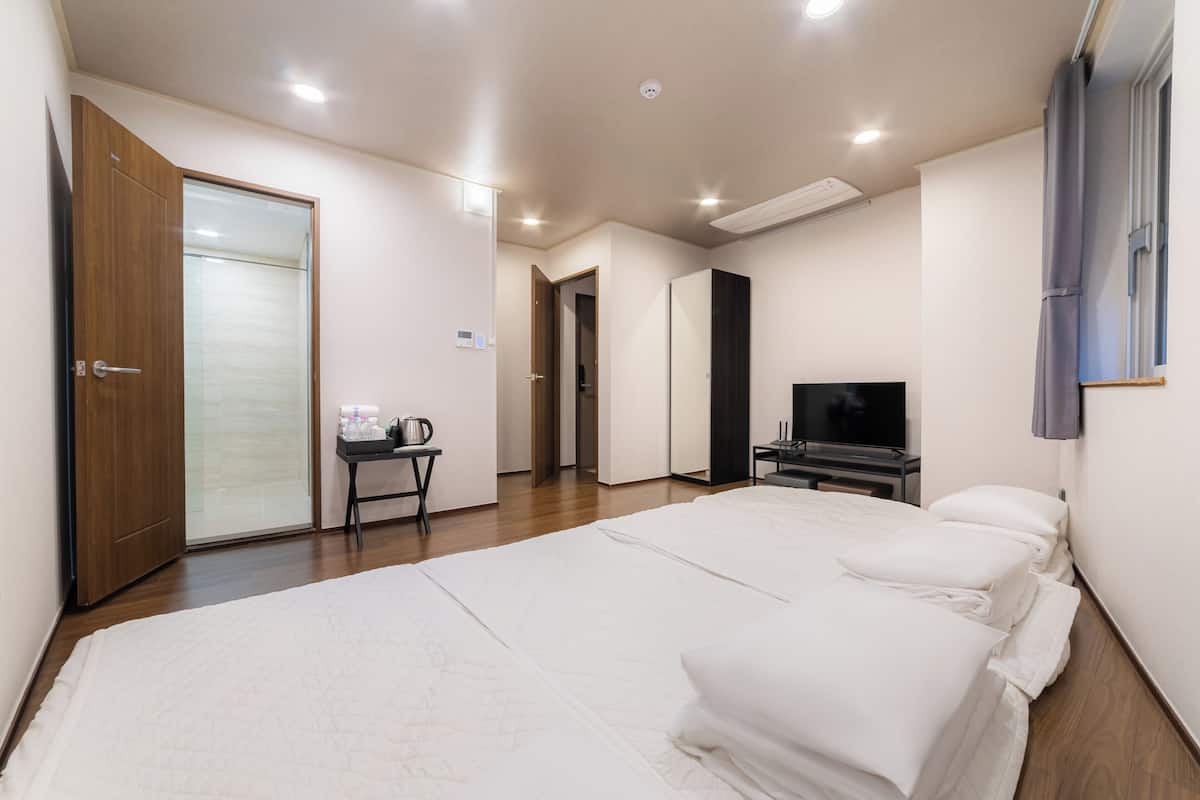 Une chambre d’hôtel avec un grand lit, une télévision, un bureau et une armoire.