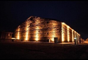 Un gran edificio de piedra iluminado durante la noche.