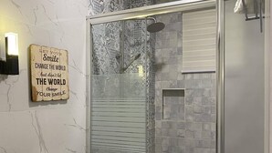 Une salle de bain moderne avec une douche à parois de verre, des toilettes blanches et un meuble-lavabo.