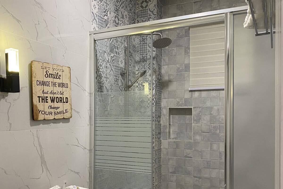 A modern bathroom with a glass-enclosed shower, a white toilet, and a vanity with a sink.