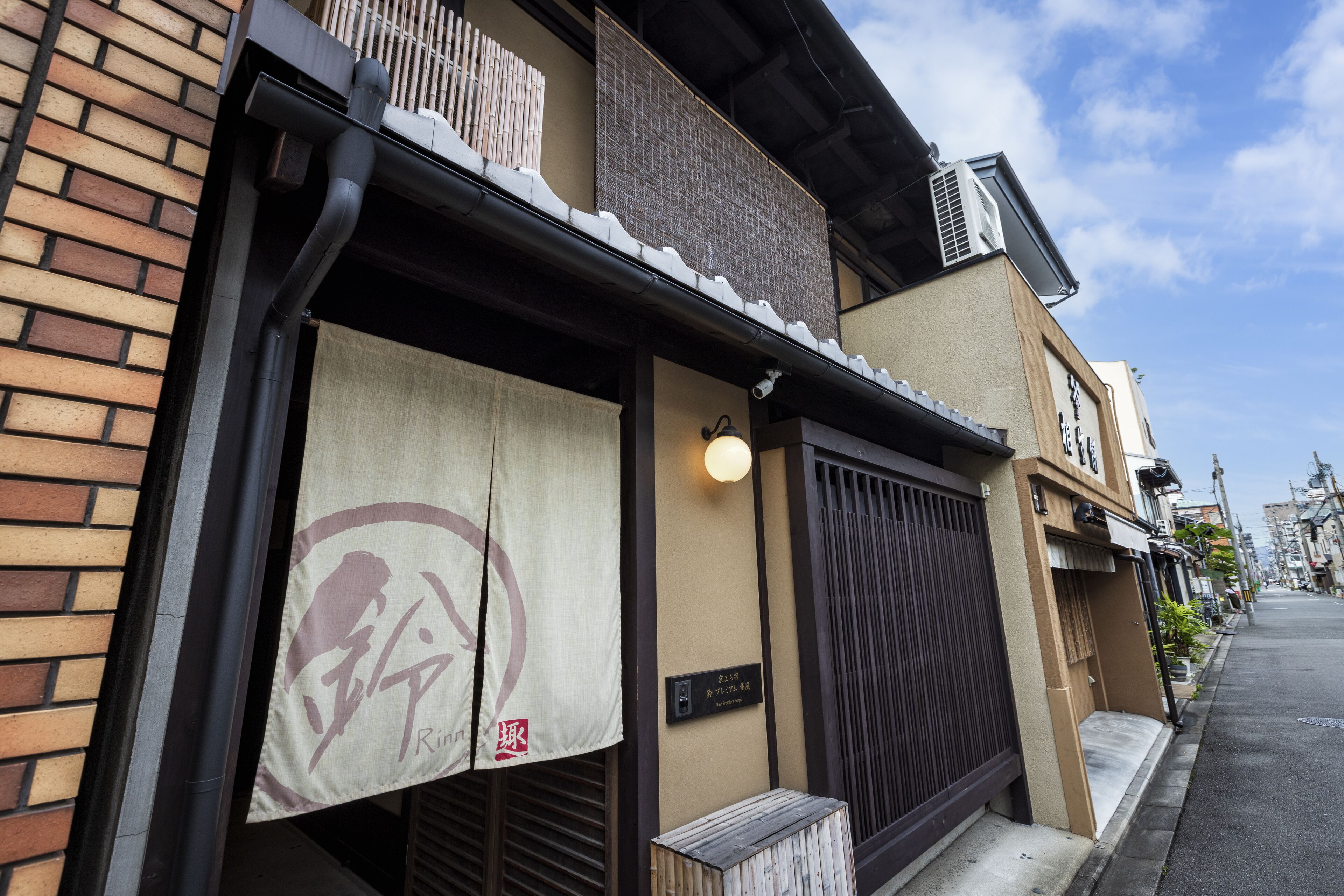 Un edificio japonés tradicional con tejado de tejas, puerta de madera y un letrero con caracteres japoneses.