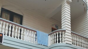 A two-story building with a balcony on the upper floor, a door on the lower floor, and potted plants in the foreground. - BnB Royal Tourist House (Kathmandu)