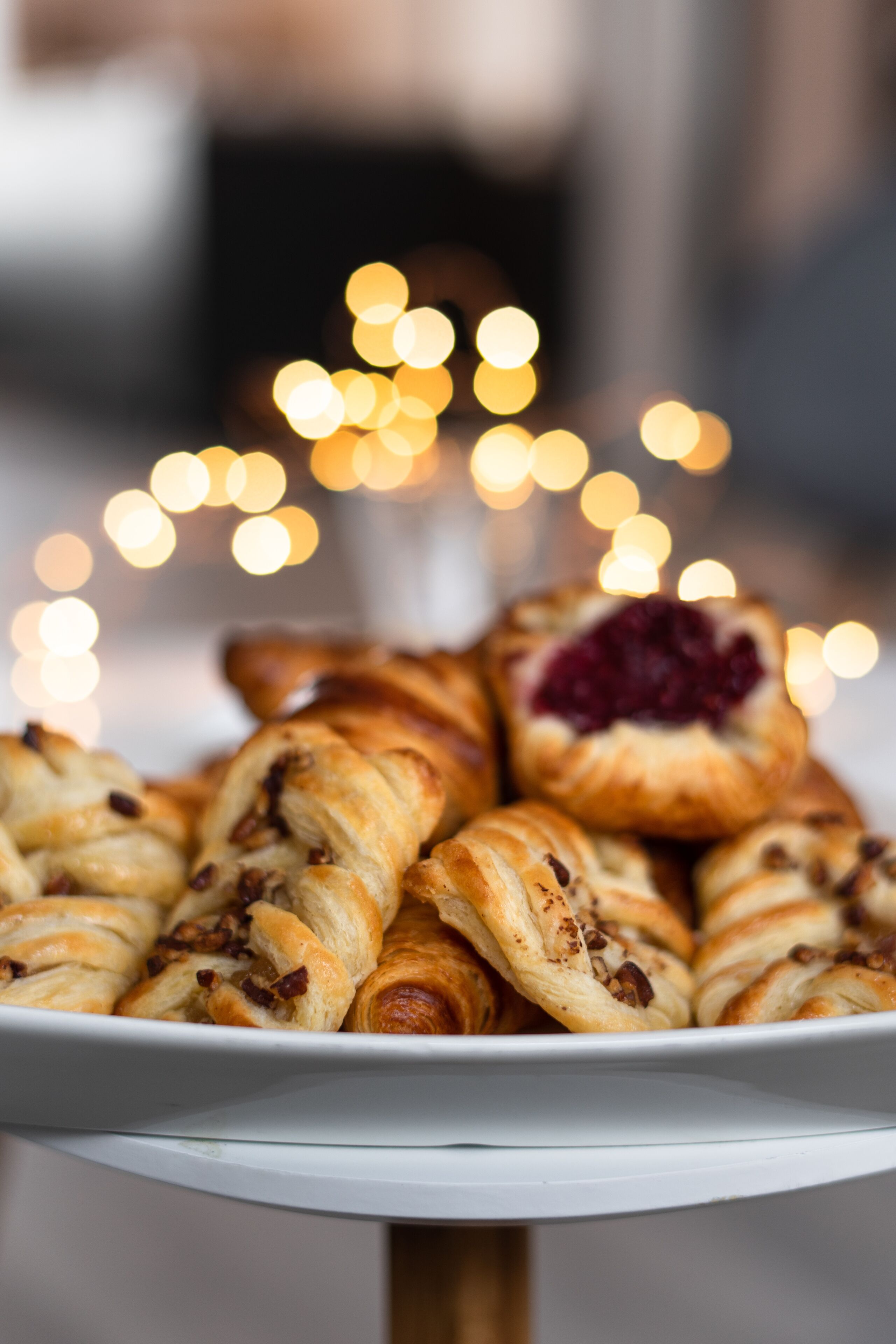 Une assiette de pâtisseries sur fond flou de lumières.