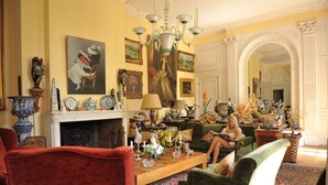 Amplia sala de estar con chimenea, asientos cómodos y varios objetos decorativos.